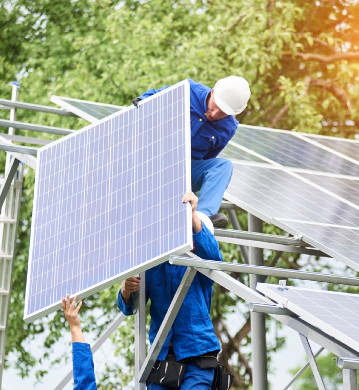 Techniciens posant un panneau solaire sur structure métallique